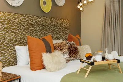 a living room with a couch with pillows and a table at Pumbaa Wildlife Park & Accommodation in Nelspruit