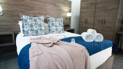 a bedroom with a bed with blue and white pillows at Alveston Manor Boutique Hotel & Spa in Middelburg