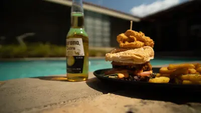 a sandwich and fries on a table with a bottle of beer at Alveston Manor Boutique Hotel & Spa in Middelburg