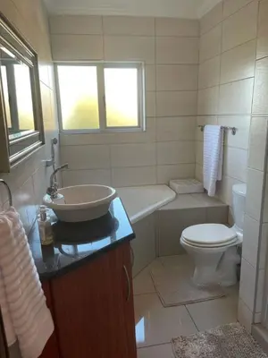 a bathroom with a sink and a toilet at Sunninghill Luxury Spacious Executive Penthouse in Sandton