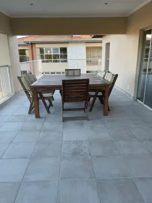 a wooden table and chairs on a patio at Sunninghill Luxury Spacious Executive Penthouse in Sandton