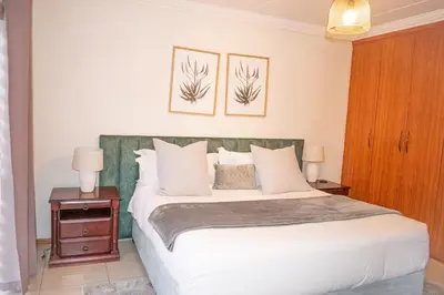 a bedroom with a bed and two pictures on the wall at Sunninghill Luxury Spacious Executive Penthouse in Sandton