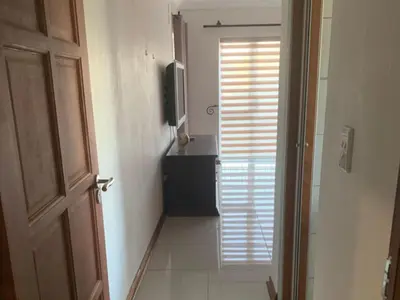 a hallway with a door to a bathroom with a television at Sunninghill Luxury Spacious Executive Penthouse in Sandton