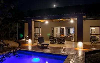 a house with a swimming pool at night at Fairfarren in Hoedspruit