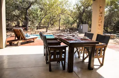 a wooden table and chairs on a patio at Fairfarren in Hoedspruit