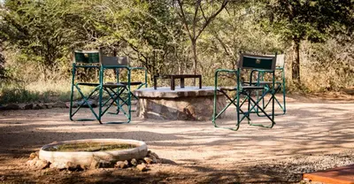 two chairs and a table and a fire pit at Fairfarren in Hoedspruit