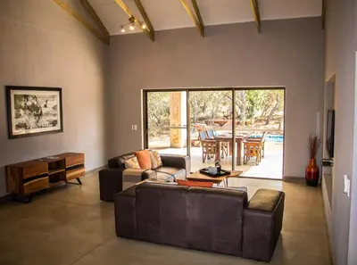 a living room with two couches and a table at Fairfarren in Hoedspruit