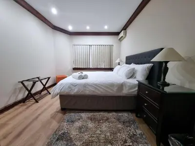 a bedroom with a bed and a dresser and a window at Cussonia Country Home in Tierpoort