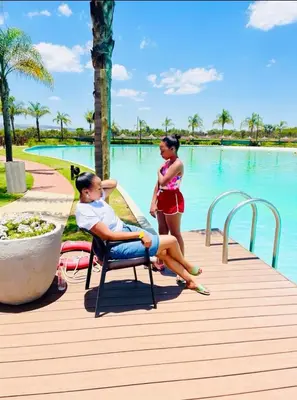 two women standing on a boardwalk near a swimming pool at The Blyde Crystal Lagoon in Pretoria