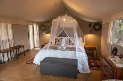 a bedroom with a bed with a canopy at Umkumbe Bush Lodge - Luxury Tented Camp in Sabi Sand Game Reserve