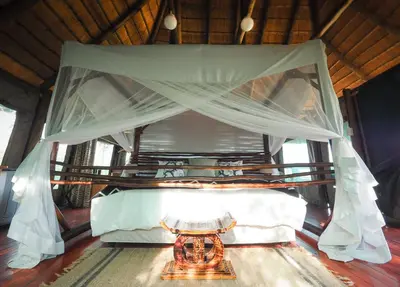 a bed in a room with a canopy at Muweti Bush Lodge in Grietjie Nature Reserve
