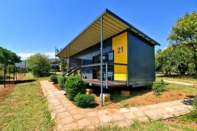 a small black and yellow house on a field at SleepOver Moria in Moria