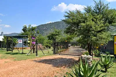 a black gate in a park with a tree at SleepOver Moria in Moria