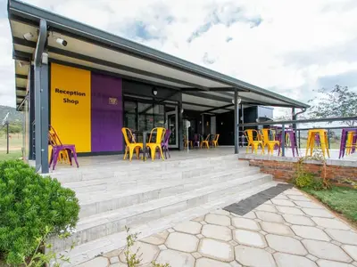 a building with colorful chairs and tables on a patio at SleepOver Moria in Moria