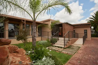 a house with a palm tree in front of it at Glen Marion Guest House in Pretoria