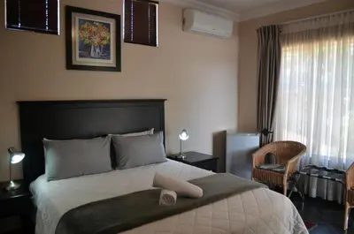a bedroom with a bed with a towel on it at Glen Marion Guest House in Pretoria