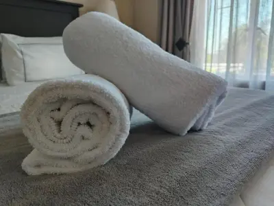 a rolled up towel on top of a bed at Glen Marion Guest House in Pretoria