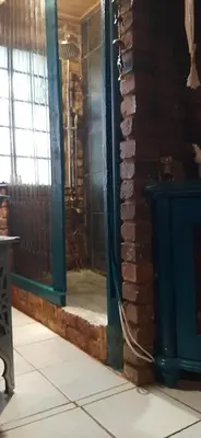 a room with a brick wall and a blue door at Wooden Creek Estate in Kempton Park