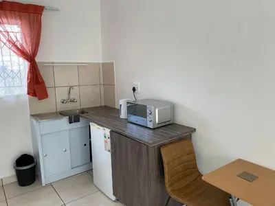 a small kitchen with a microwave on top of a counter at La Fiance Village in Polokwane