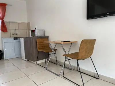 a small table and two chairs in a kitchen at La Fiance Village in Polokwane