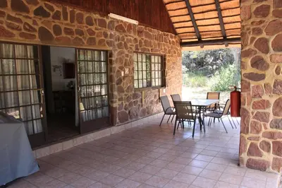 a patio with a table and chairs in a stone building at Moletani Game Ranch in Kareefontein