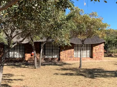 a stone building with two trees in front of it at Moletani Game Ranch in Kareefontein
