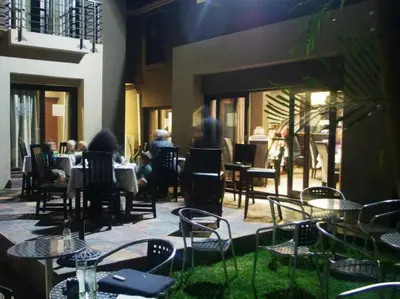 a group of people sitting at tables in a restaurant at Kusile Guest House in Burgersfort