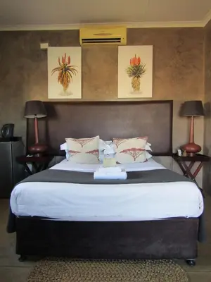 a bedroom with a large bed with two lamps at Kusile Guest House in Burgersfort