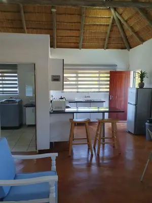 a kitchen with a table and chairs in a room at Pomegranate Selfcatering apartment in Nelspruit