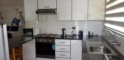 a kitchen with a sink and a stove top oven at Pomegranate Selfcatering apartment in Nelspruit