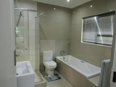a bathroom with a toilet and a tub and a sink at Pafuri Gate Guesthouse in Mabalingwe Game Reserve