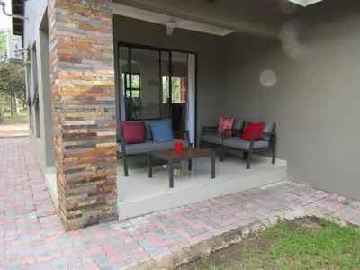 a patio with chairs and a table on a house at Pafuri Gate Guesthouse in Mabalingwe Game Reserve
