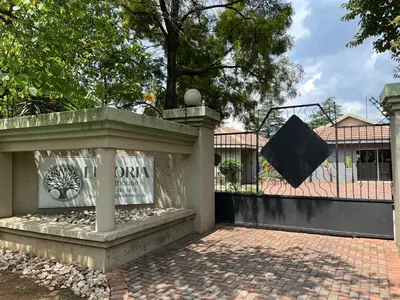 a sign on a fence in front of a building at Euforia Guesthouse in Middelburg