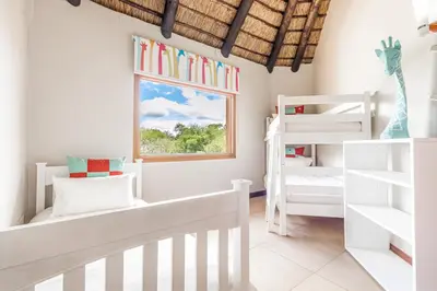 a white room with two bunk beds and a window at Waterberg House at Zebula 8 adults and 4 kids in Mabula