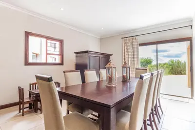 a dining room with a wooden table and chairs at Waterberg House at Zebula 8 adults and 4 kids in Mabula