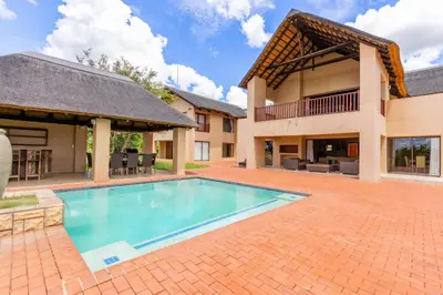 a swimming pool in the backyard of a house at Waterberg House at Zebula 8 adults and 4 kids in Mabula
