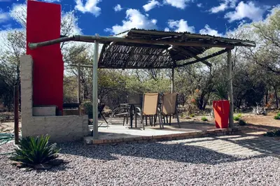 a pergola with two chairs and a table at Bush Inn Lodge Lephalale in Lephalale