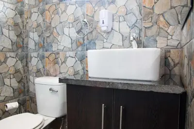 a bathroom with a white toilet and a sink at Bush Inn Lodge Lephalale in Lephalale