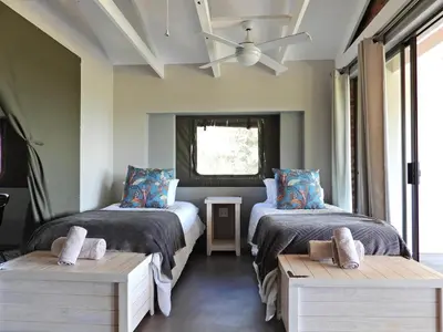 a bedroom with two beds and a ceiling fan at Newburg Lodge & Luxury Bush Tents, Elements Private Golf Reserve in Moheme