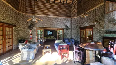 a living room with furniture and a brick wall at Greenfire Hazyview Lodge in Hazyview