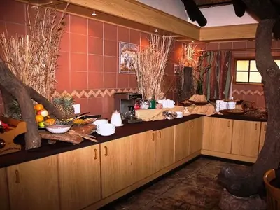 a kitchen with wooden cabinets and fruits on the counter at Golden Pillow Guest House in Polokwane
