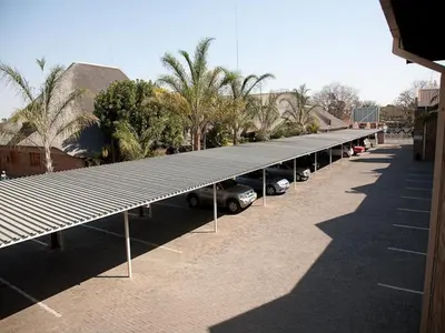 a row of parked cars in a parking lot at Golden Pillow Guest House in Polokwane