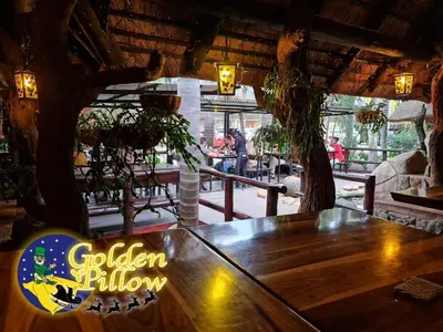 a restaurant with a wooden table in a room at Golden Pillow Guest House in Polokwane