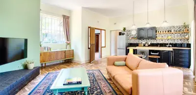 a living room with a couch and a tv at The BeeKeeper's Inn in Louis Trichardt