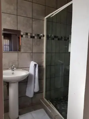 a bathroom with a sink and a shower at Aloe 40 in Burgersfort
