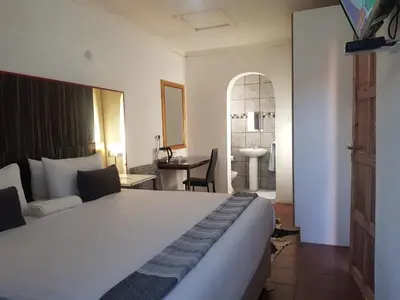 a bedroom with a large white bed and a bathroom at Aloe 40 in Burgersfort
