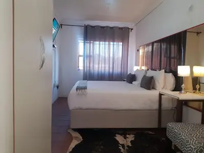 a bedroom with a large bed and a window at Aloe 40 in Burgersfort