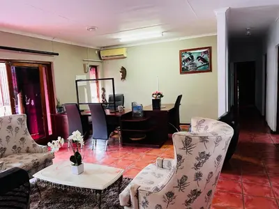 a living room with chairs and a table and a desk at Aloe 40 in Burgersfort