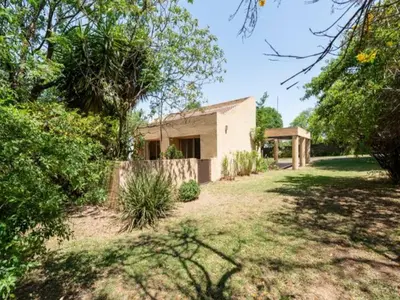 a house in the middle of a yard with trees at 1 Bedroom Cottage in Midrand