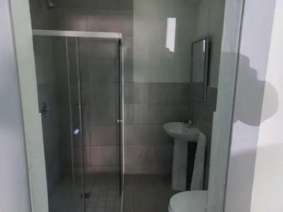 a bathroom with a shower and a toilet and a sink at Triple9 Hatfield Guesthouse in Pretoria
